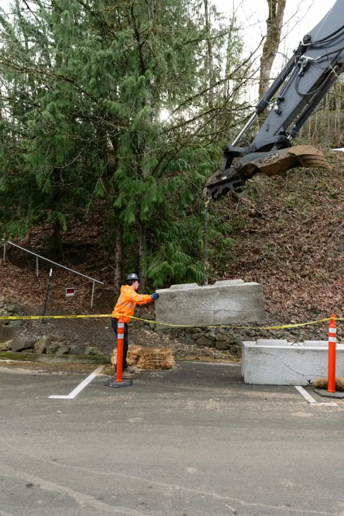 Worker guiding concrete barrier placement